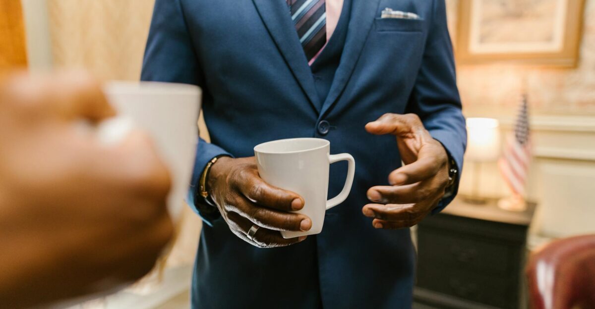 Two professionals engaging in conversation over coffee during a business meeting