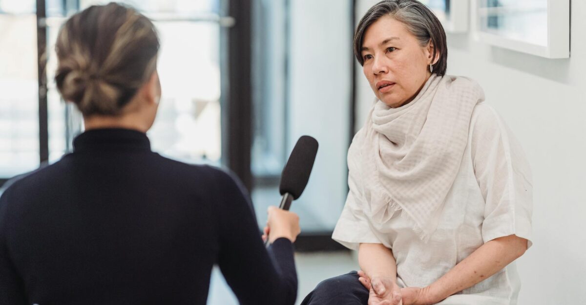 Professional interview setting with a female journalist and woman discussing indoors