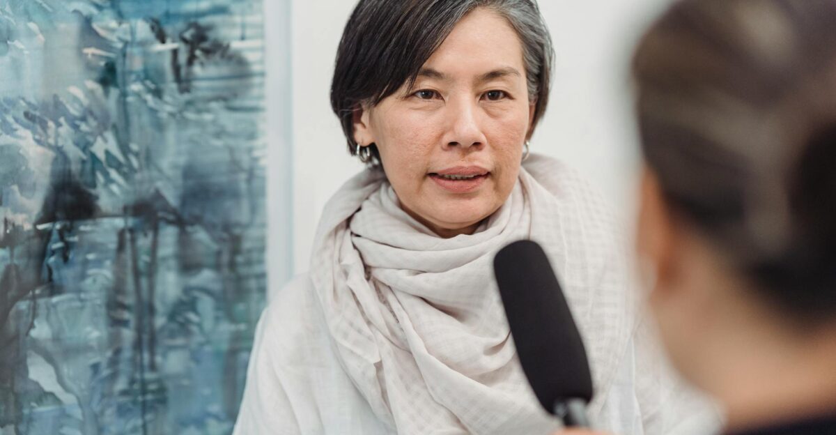Asian woman in discussion with a journalist at an indoor art gallery