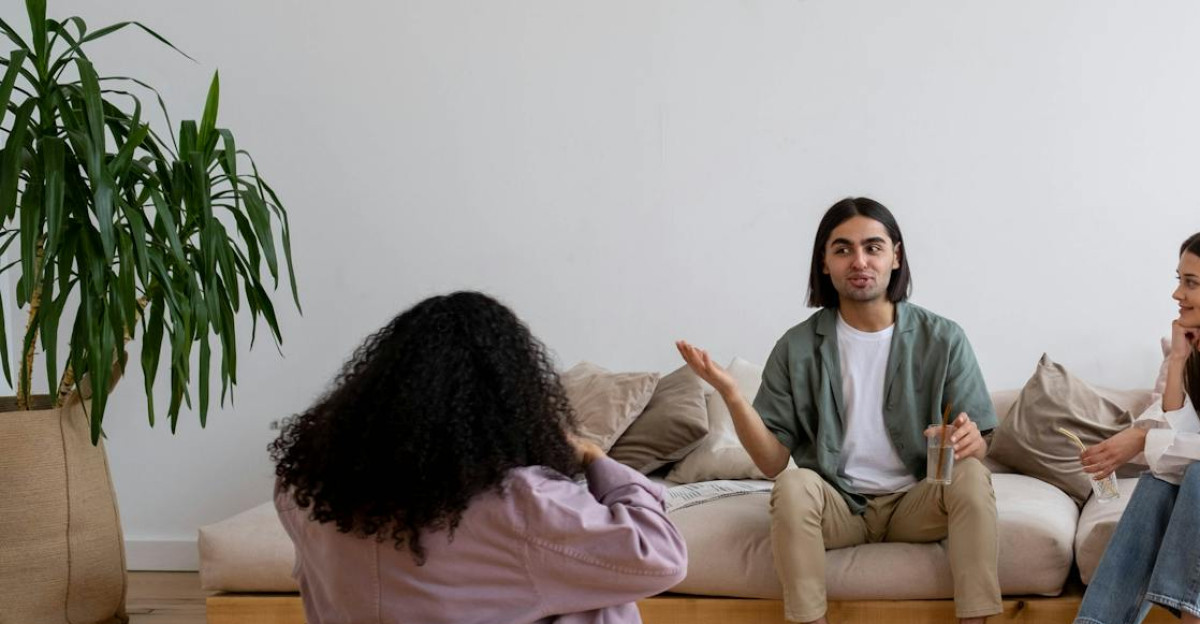 A group of diverse friends engaged in conversation in a modern living room