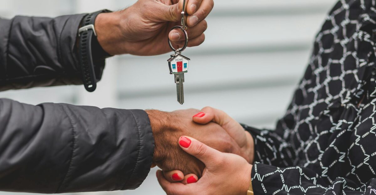 Close-up of a realtor handing over a house key to a new homeowner symbolizing ownership and investment