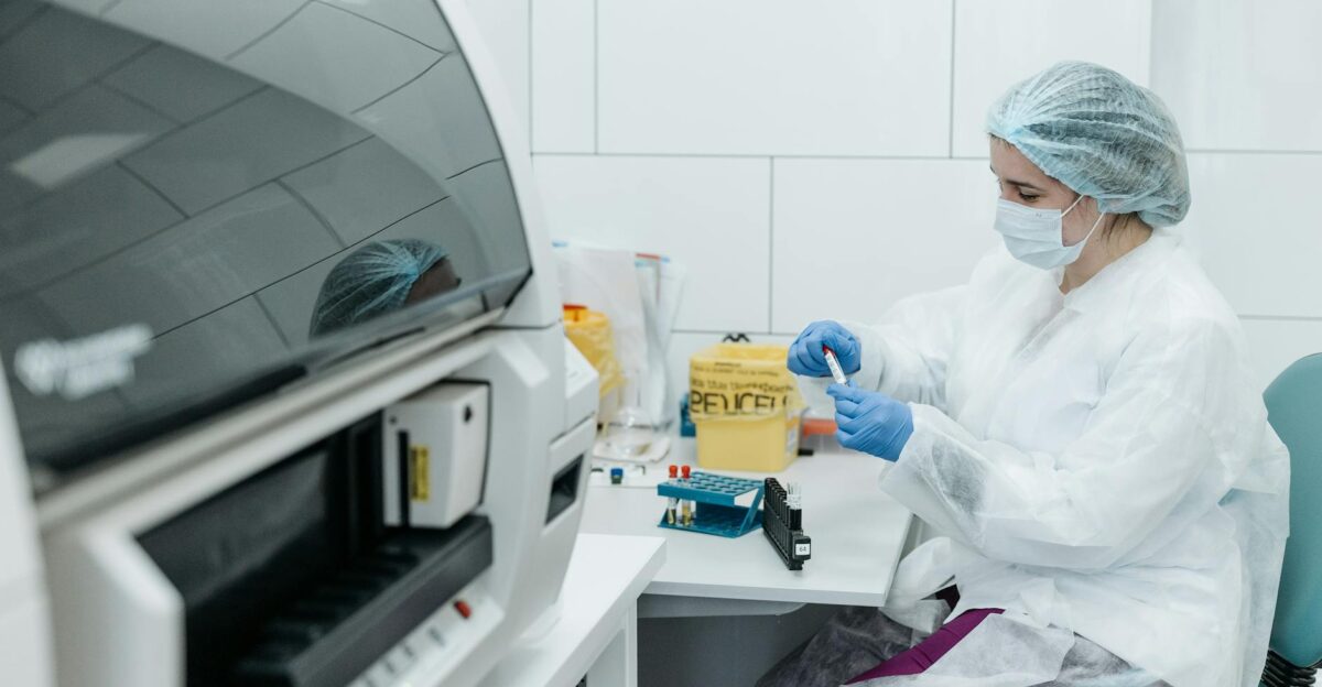 Scientist in protective gear examining samples in a medical lab setting focusing on research