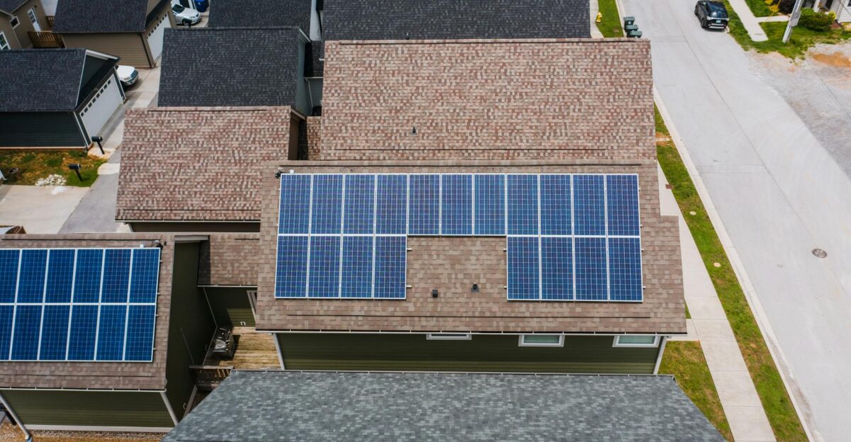 Drone shot of solar panels on residential roofs promoting eco-friendly energy solutions