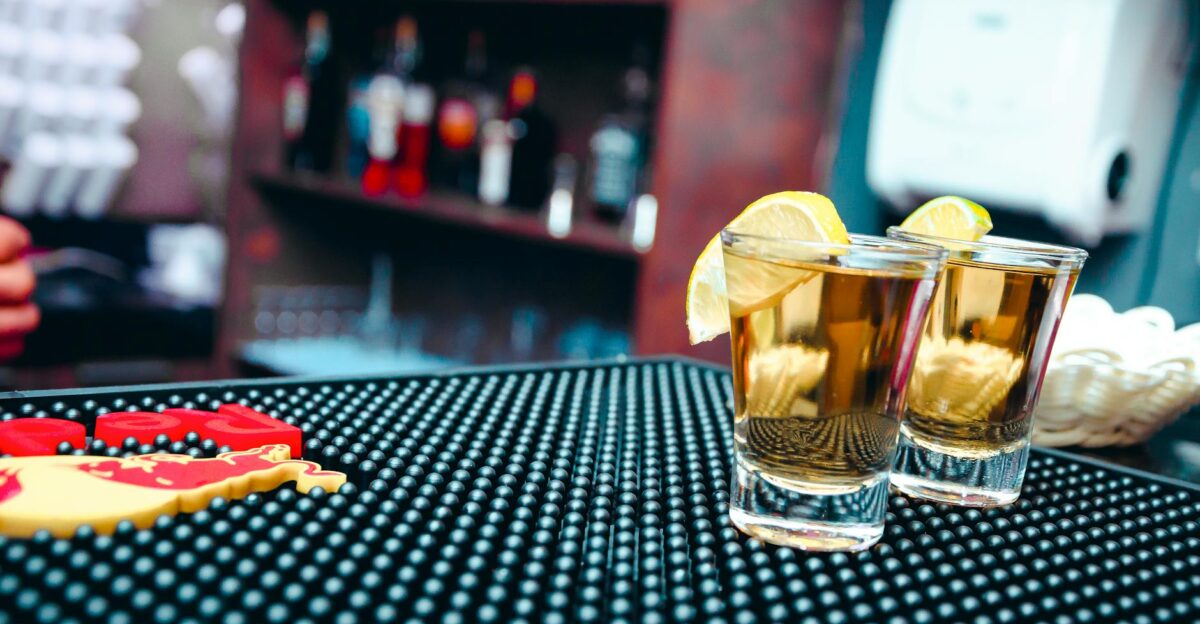 Close-up of tequila shots with lemon slices at a bar ideal for nightlife scenes