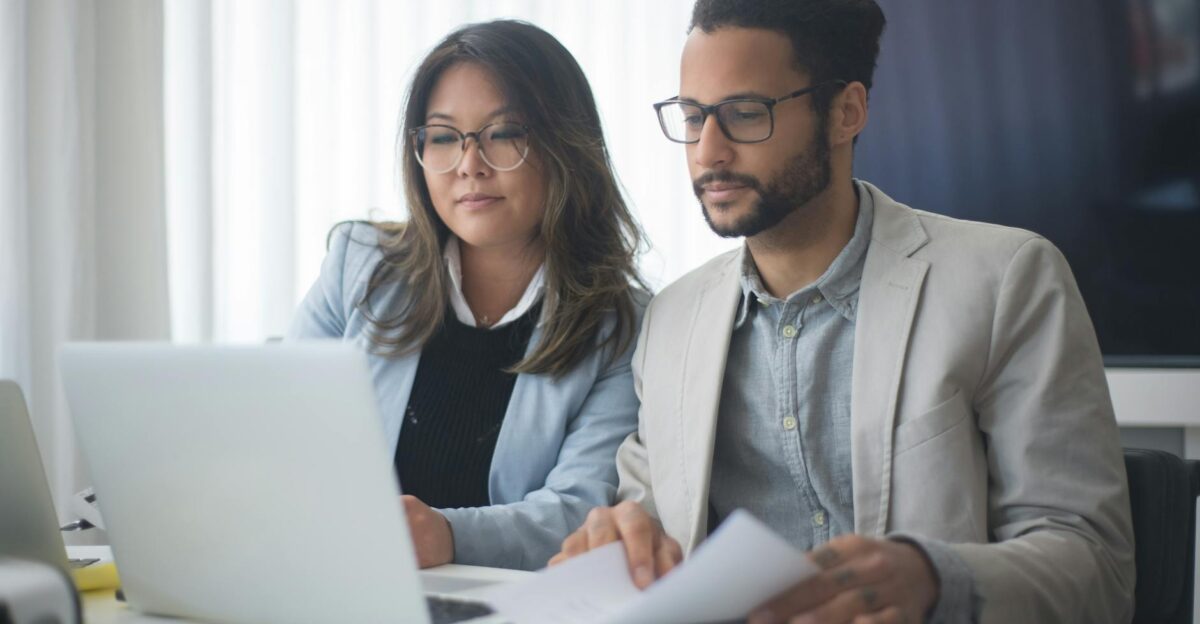 Two colleagues working together on a project in a modern office setting emphasizing teamwork and cooperation