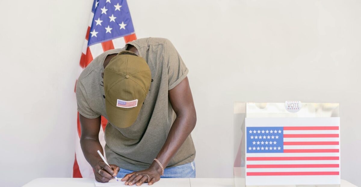 Man casting vote at polling station with American flag in background