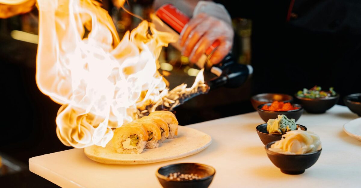 Chef using a blow torch to prepare sushi showcasing culinary skills and Japanese cuisine