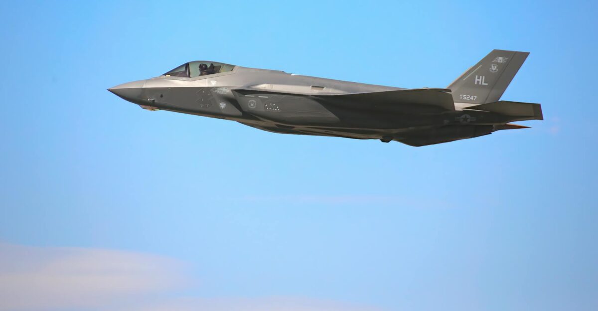 A sleek F-35A military jet flying against a clear blue sky in Nevada