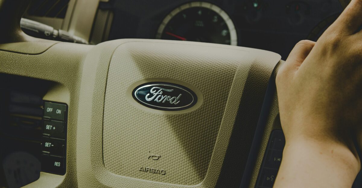person holding Ford steering wheel