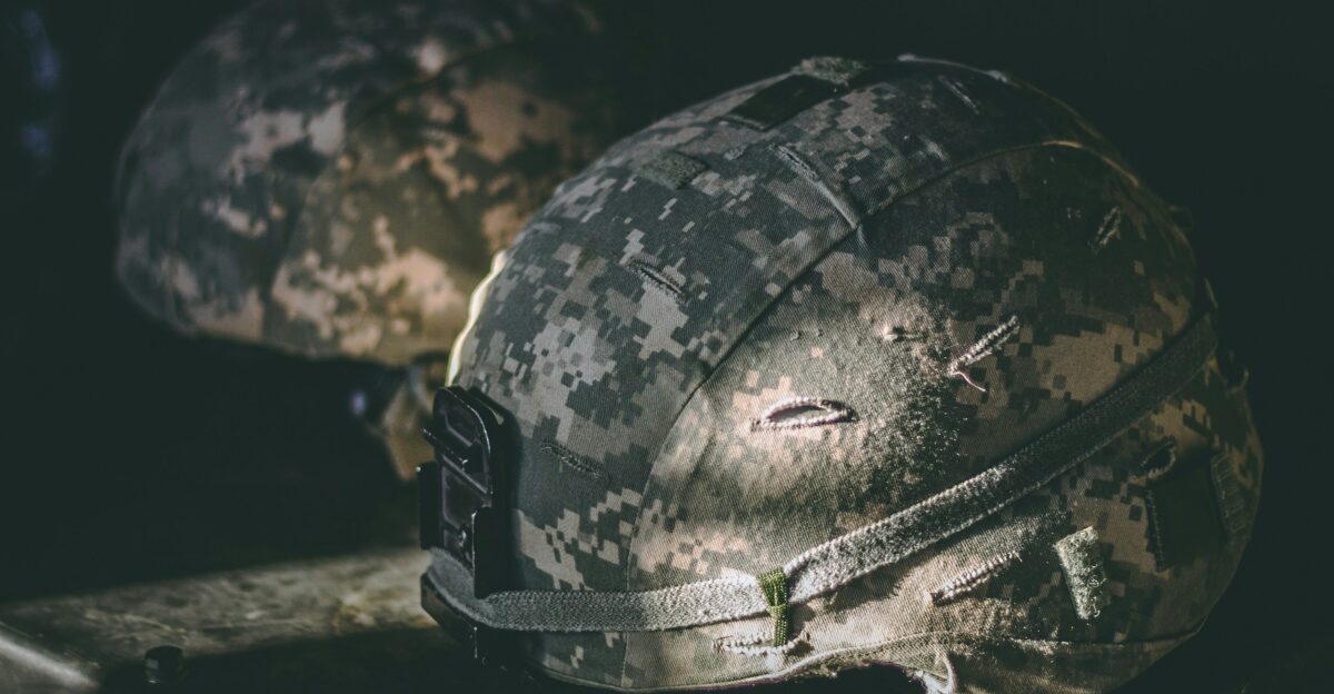 gray and brown camouflage nutshell helmet on table
