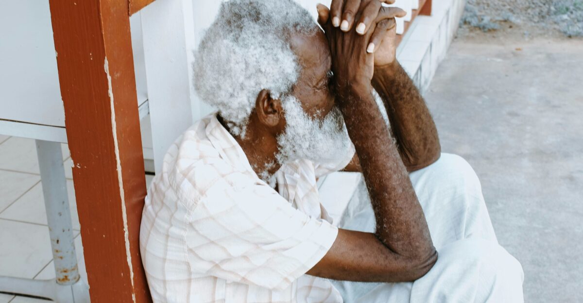 man sitting on curb leaning against balustrade at daytime