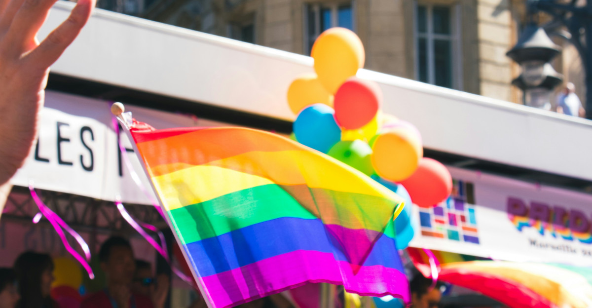people holding yellow green blue and purple flag