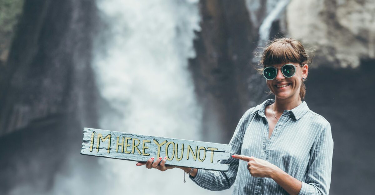 a woman holding a sign that says i m here yount