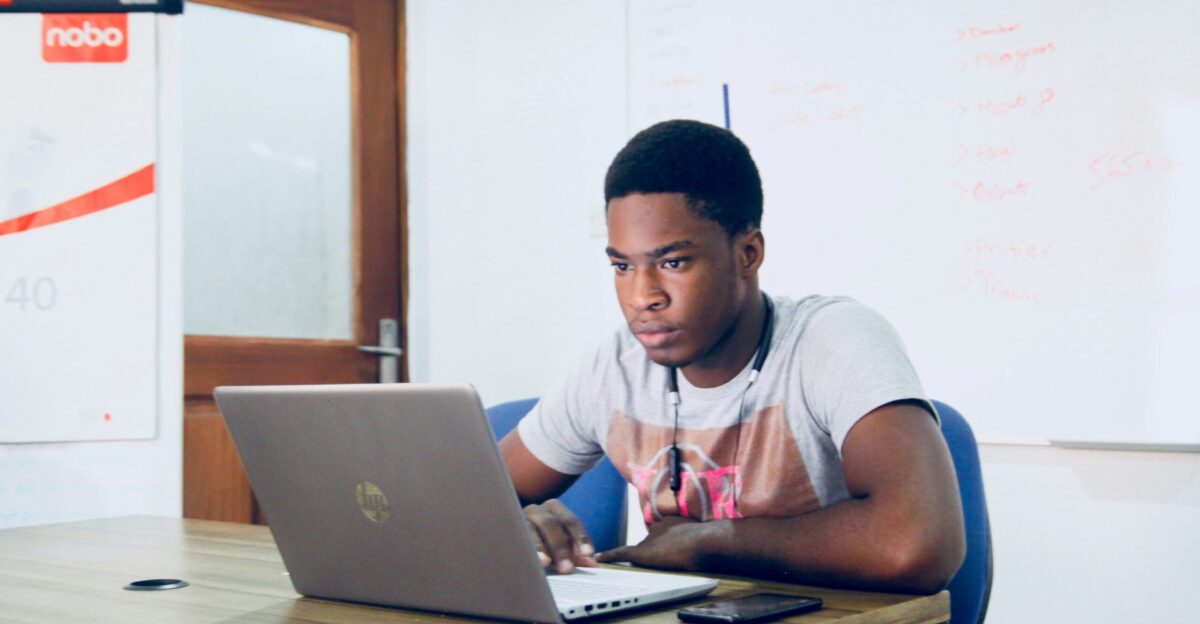 man in grey shirt using grey laptop computer