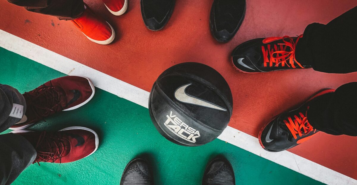 five persons standing in front of black and white Nike basketball