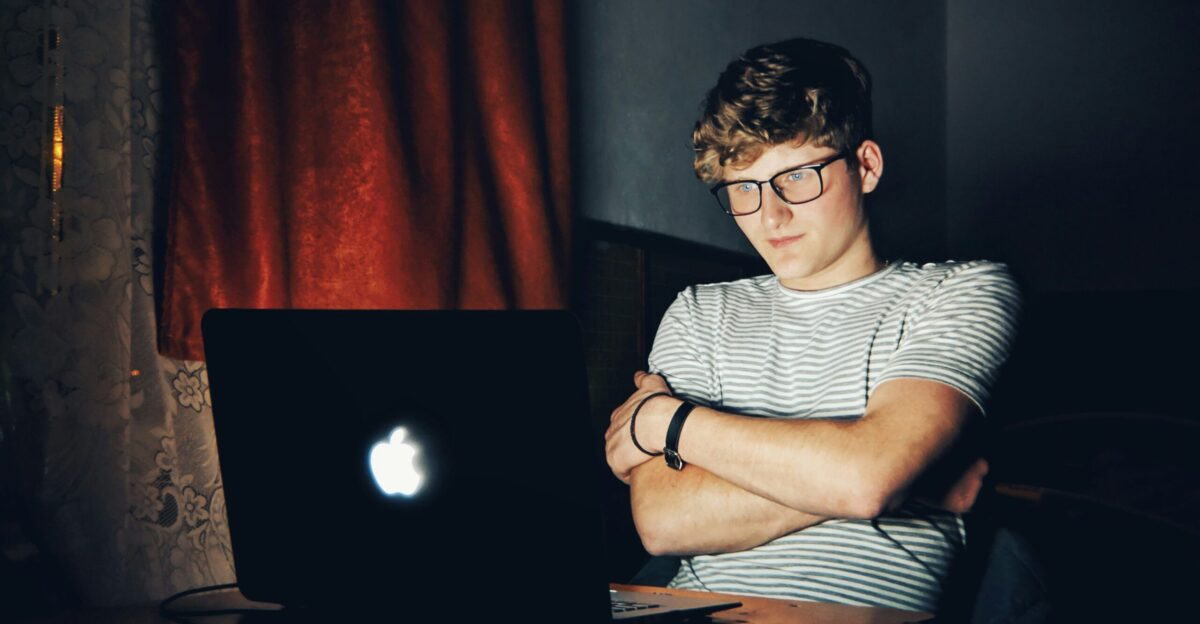 man looking at turned on MacBook