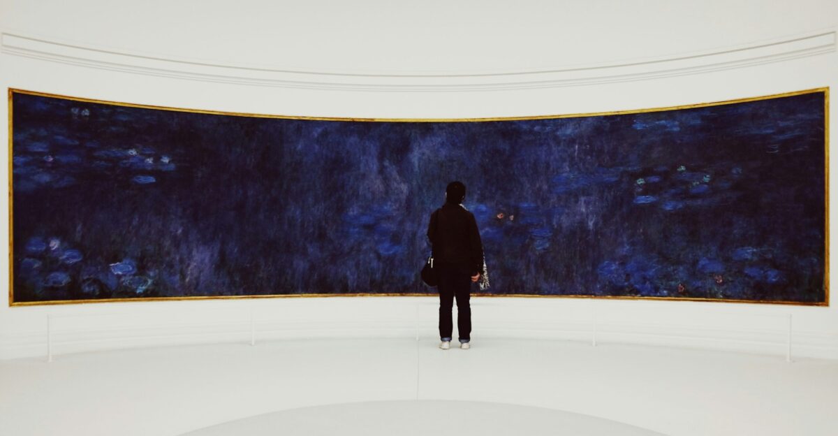 person standing beside blue wall