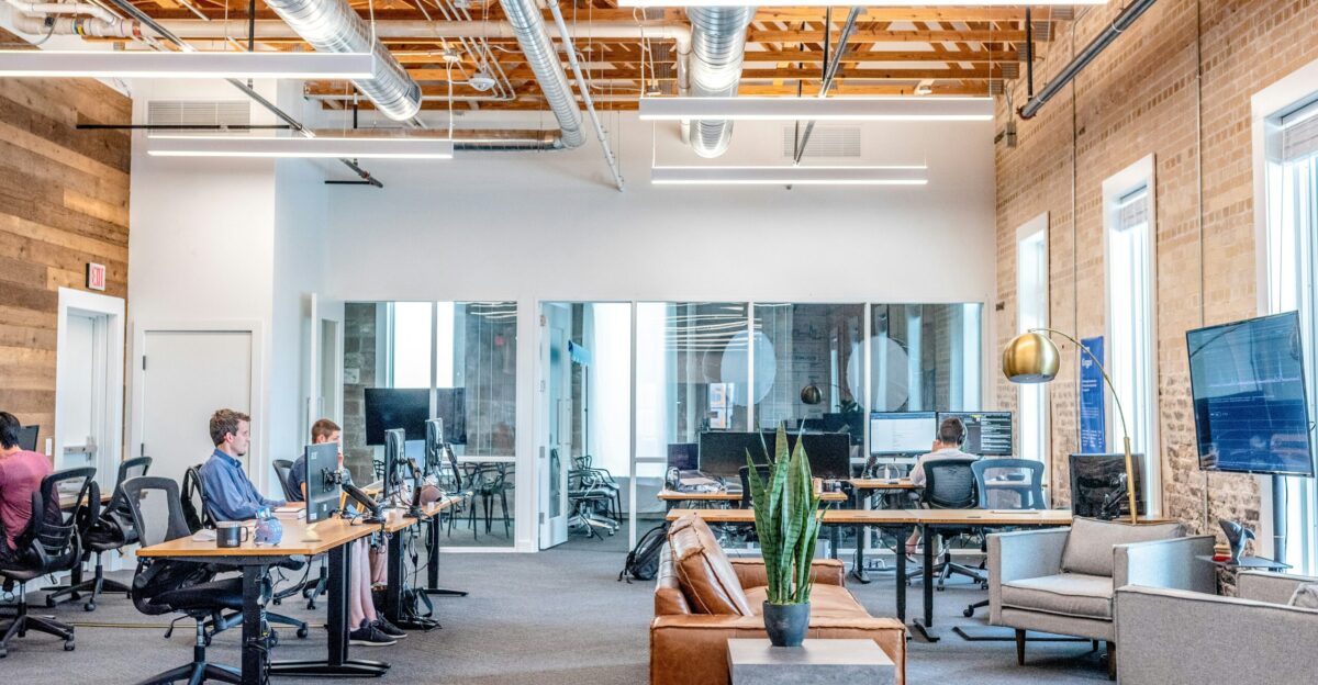 man in blue dress shirt sitting on rolling chair inside room with monitors