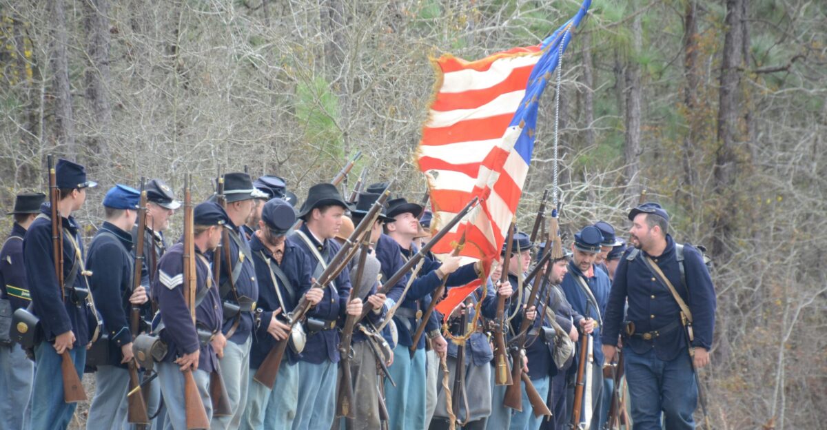 group of men holding rifles and flag