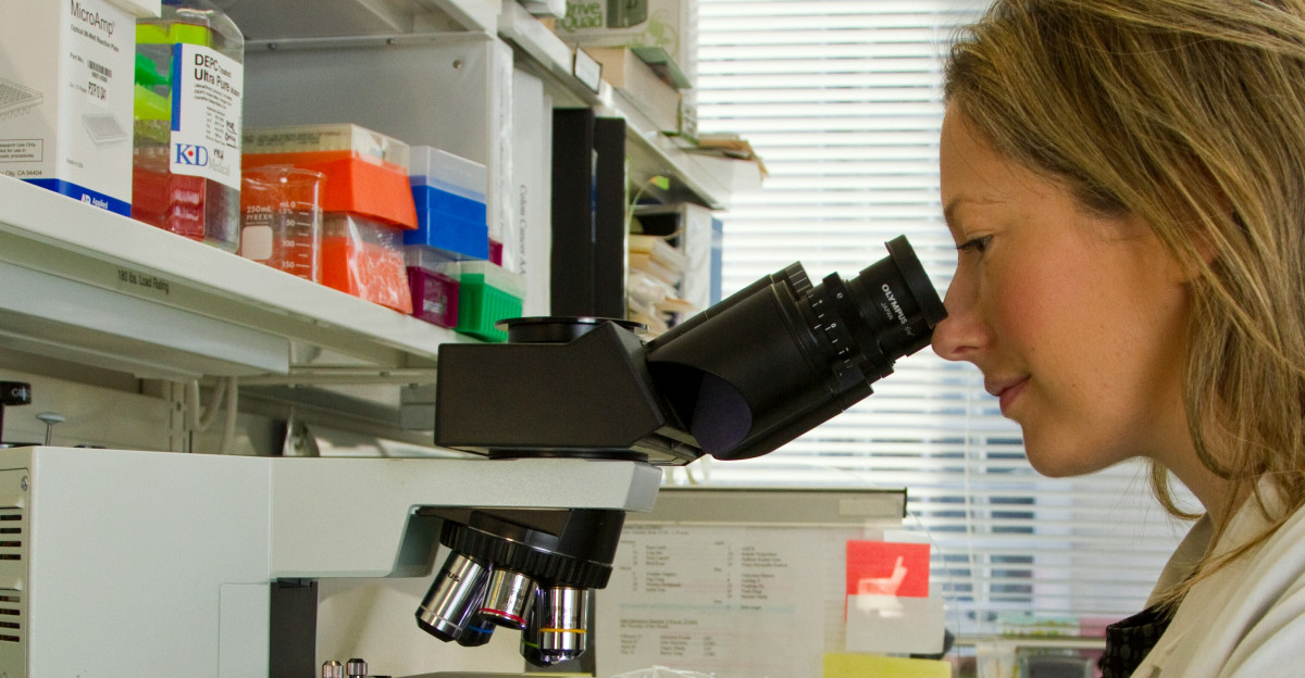 woman in white coat holding black dslr camera