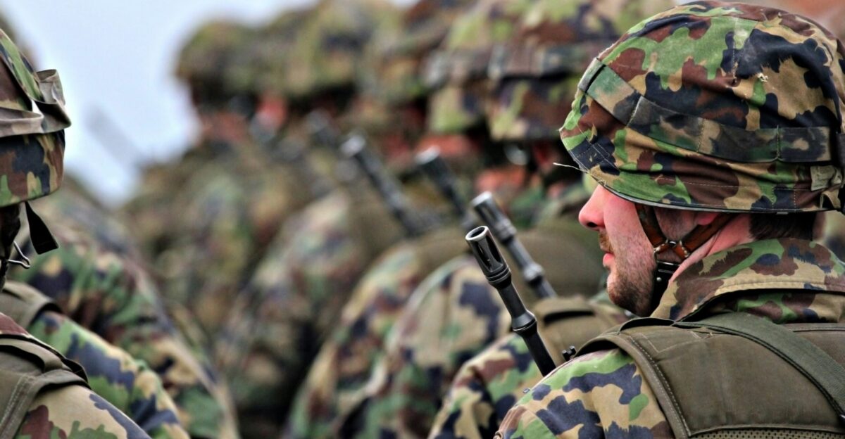 man in green and brown camouflage uniform holding black rifle