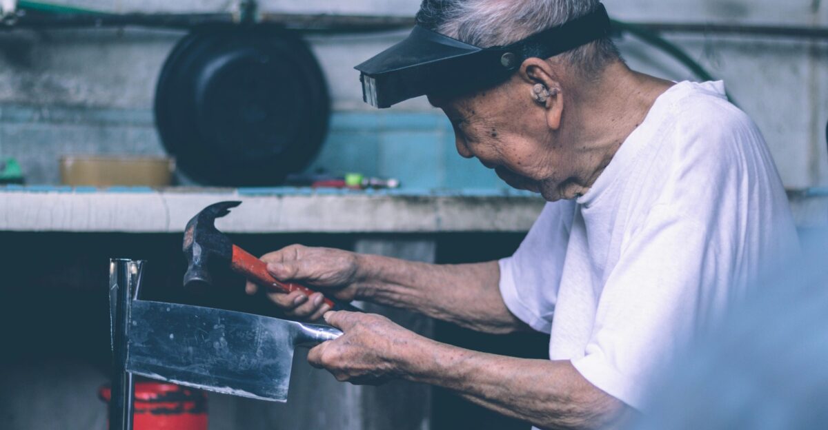 man in white t-shirt holding black metal tray