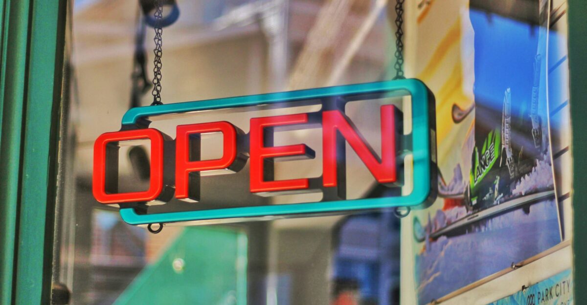 an open sign hanging from the side of a building