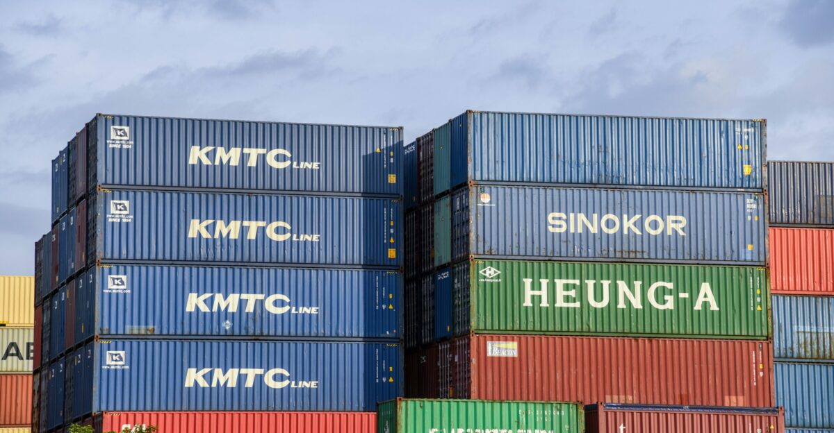 stack of intermodal containers under gray clouds