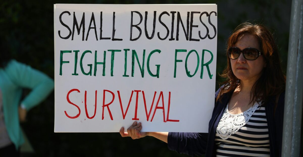 woman in black cardigan holding happy birthday signage