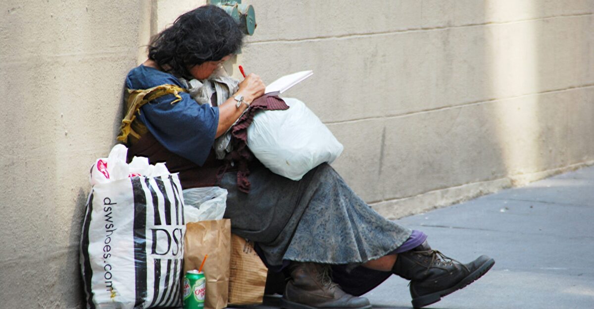 woman in black leather jacket sitting on concrete bench