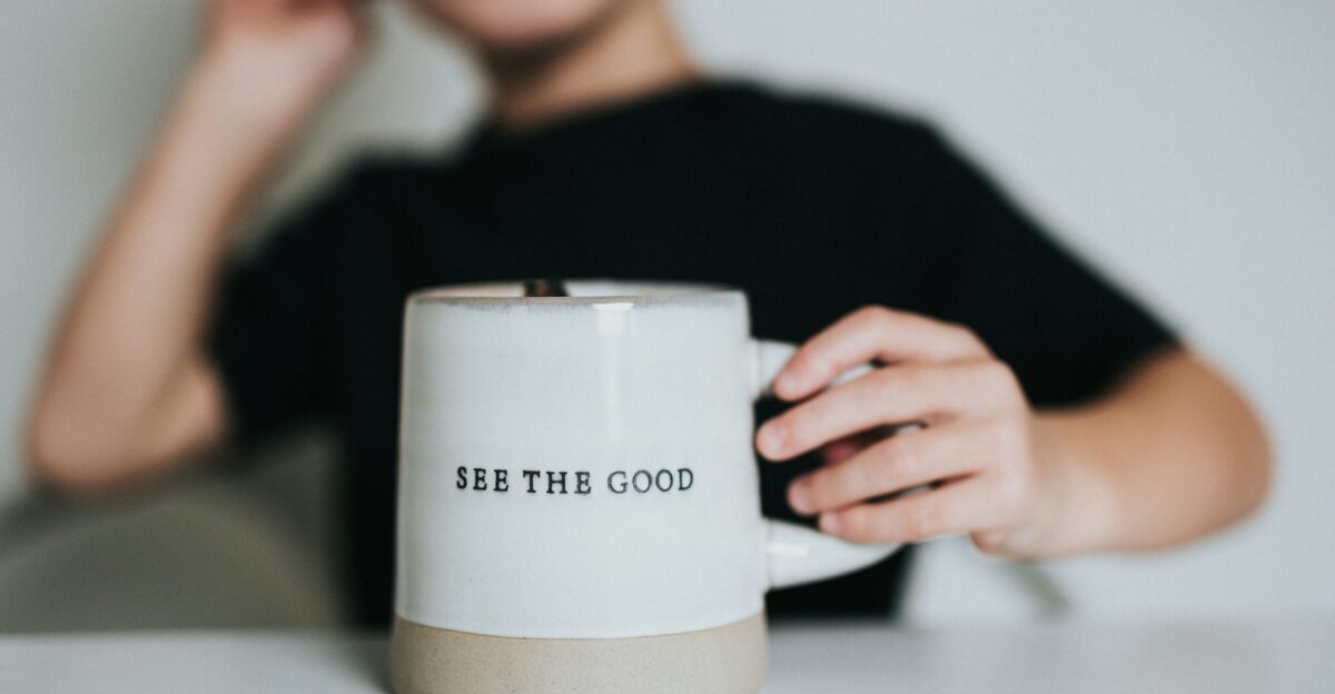 woman in black shirt holding white ceramic mug