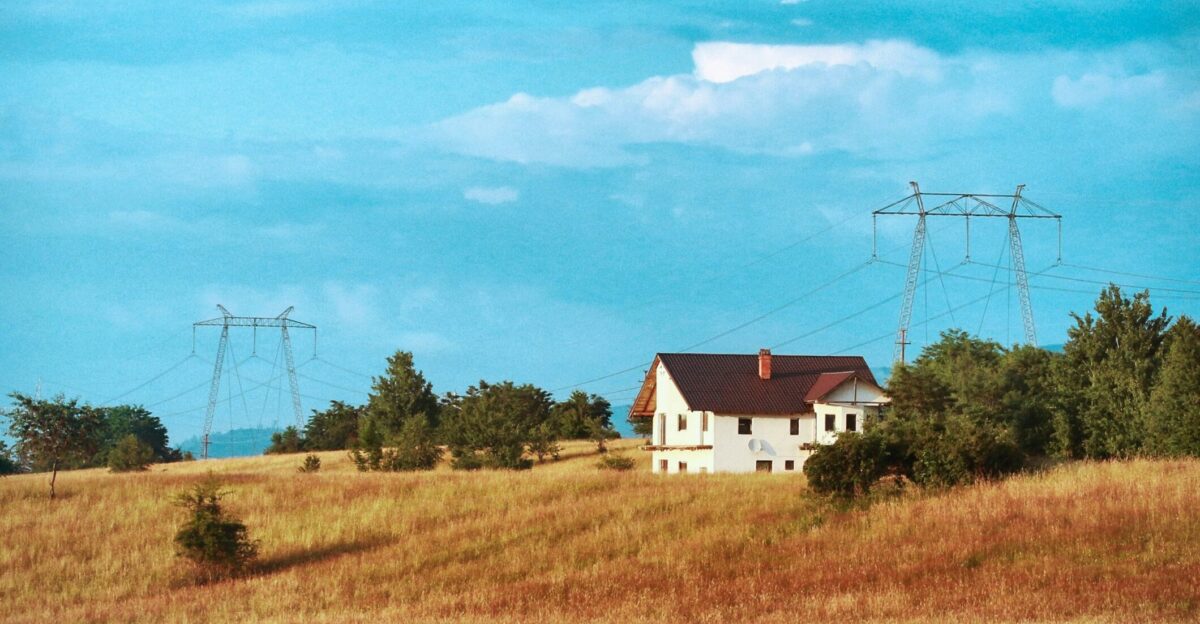 white and red house on green grass field under blue sky during daytime