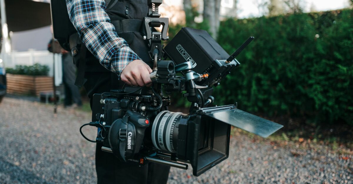 a man holding a camera and a video camera