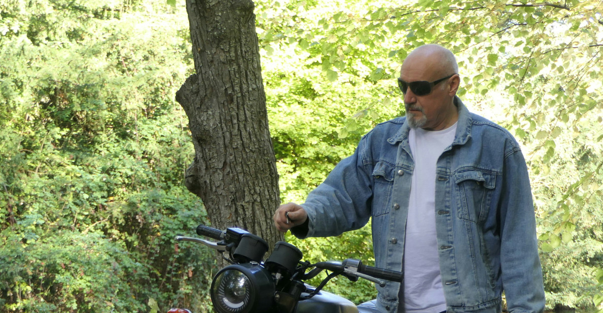 a man standing next to a black motorcycle