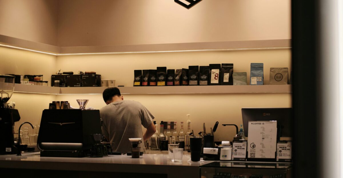 a man behind a counter in a coffee shop