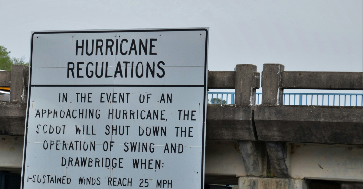 a sign on the side of a bridge warning of hurricanes