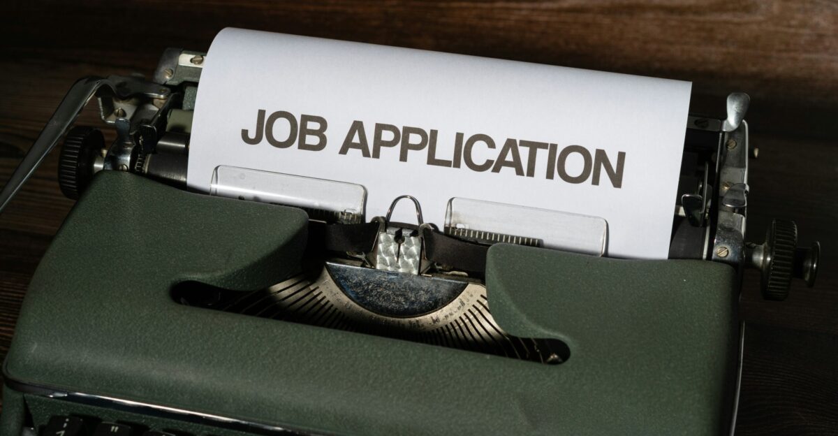 a typewriter with a job application printed on it