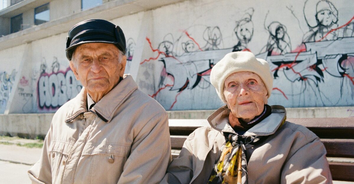 a man and woman standing in front of a wall with graffiti
