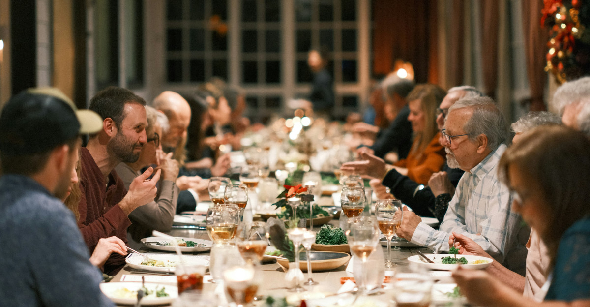 a group of people sitting at a long table