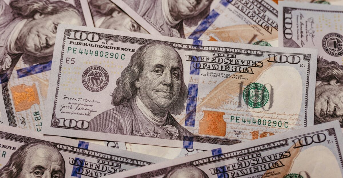 a pile of one hundred dollar bills