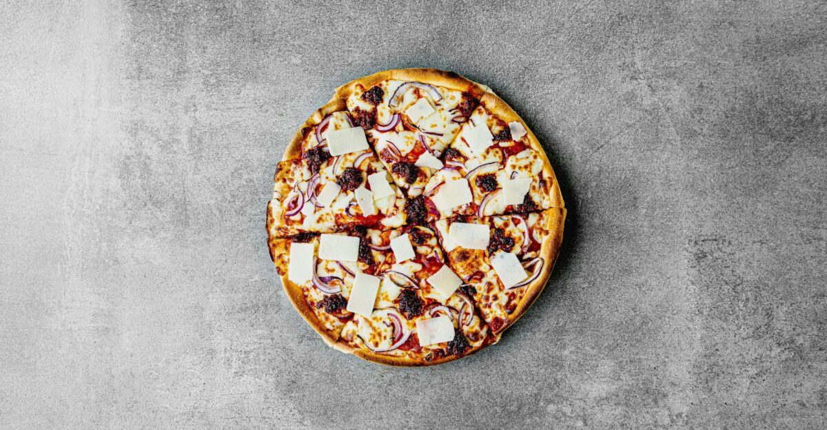 a pizza sitting on top of a pan covered in cheese