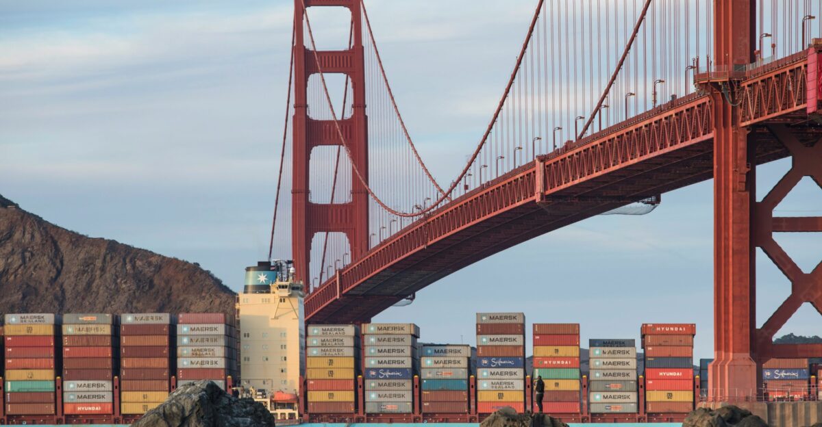 a large cargo ship passing under a bridge