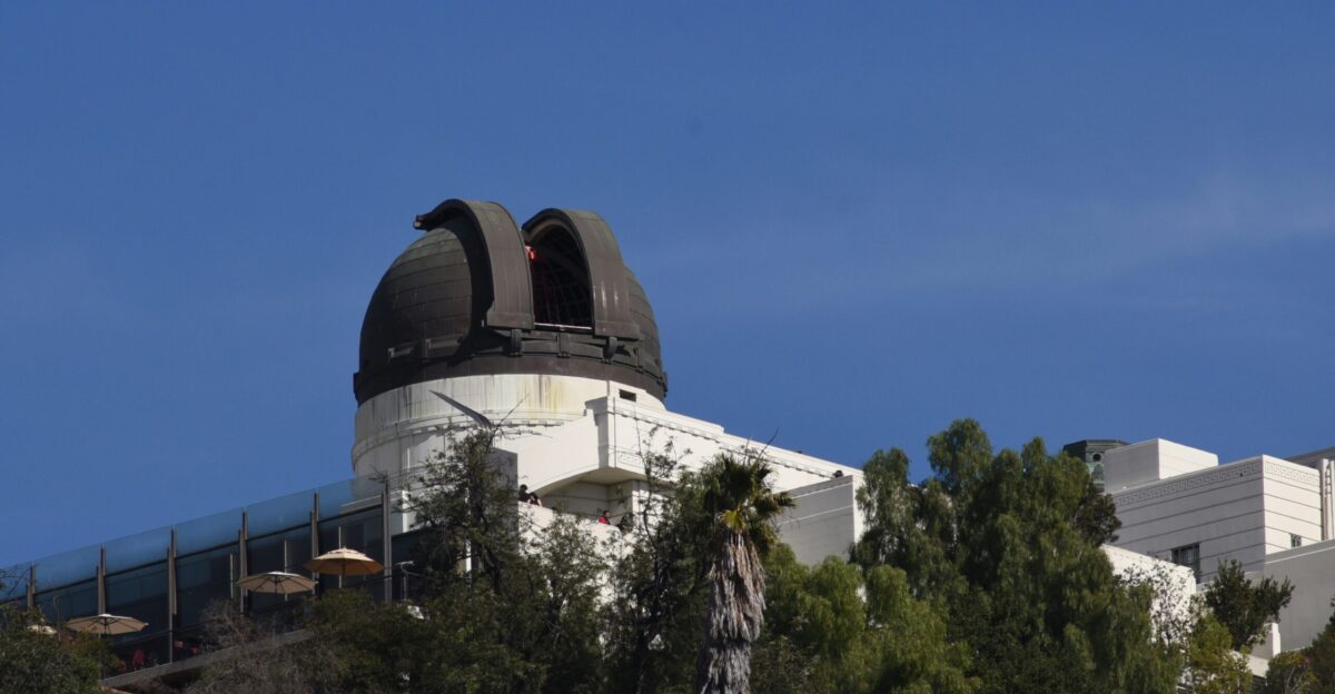 a telescope on top of a building surrounded by trees