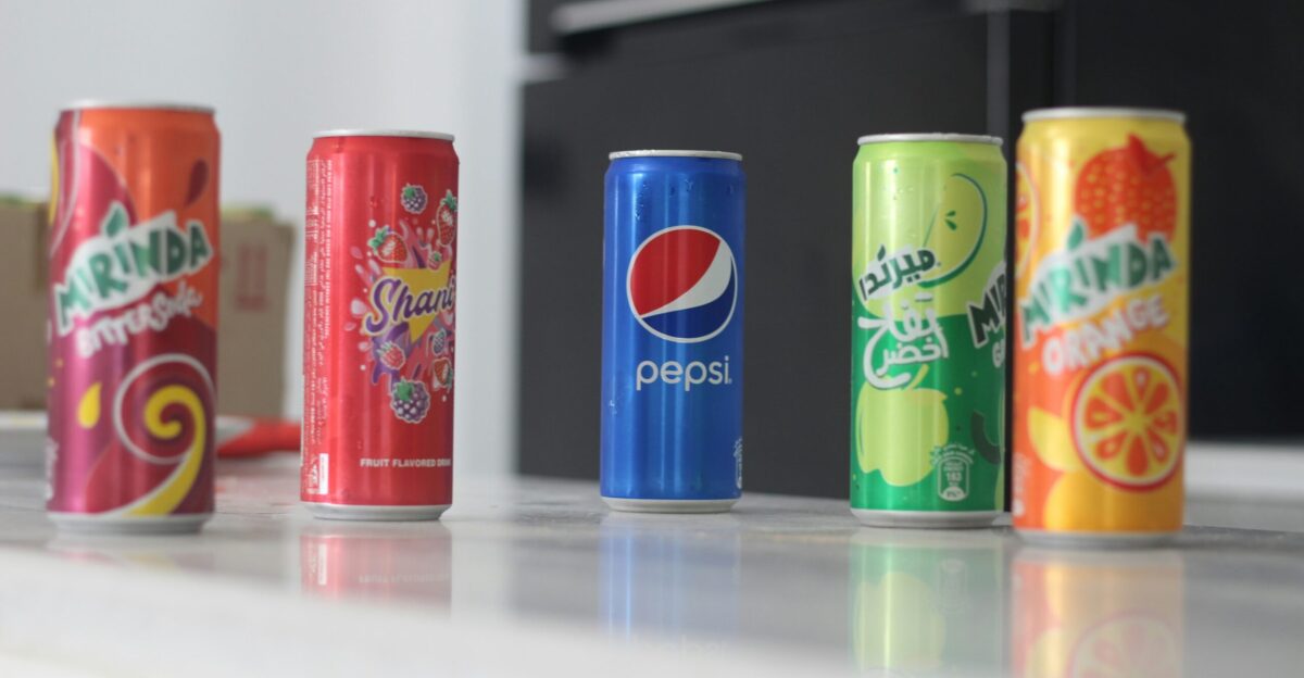 a row of soda cans sitting on top of a counter