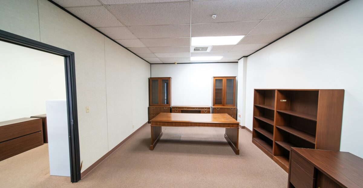 a room with a desk and a book shelf