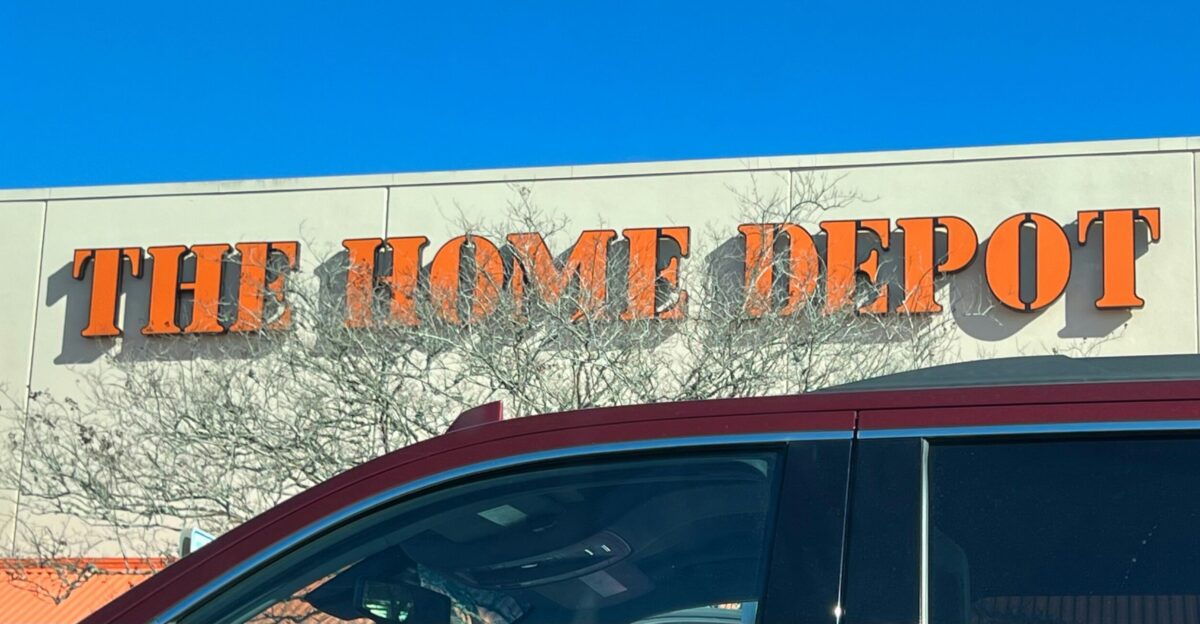 a red car parked in front of a home depot