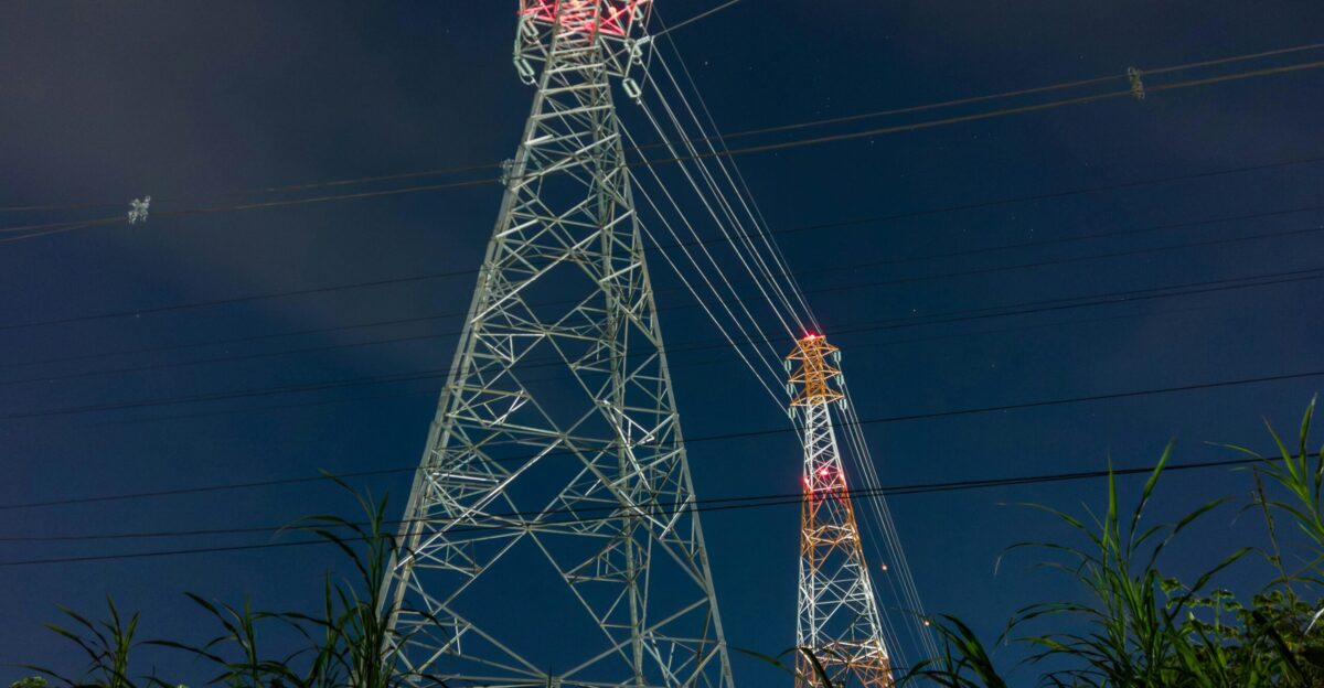 a tall tower sitting next to a lush green field