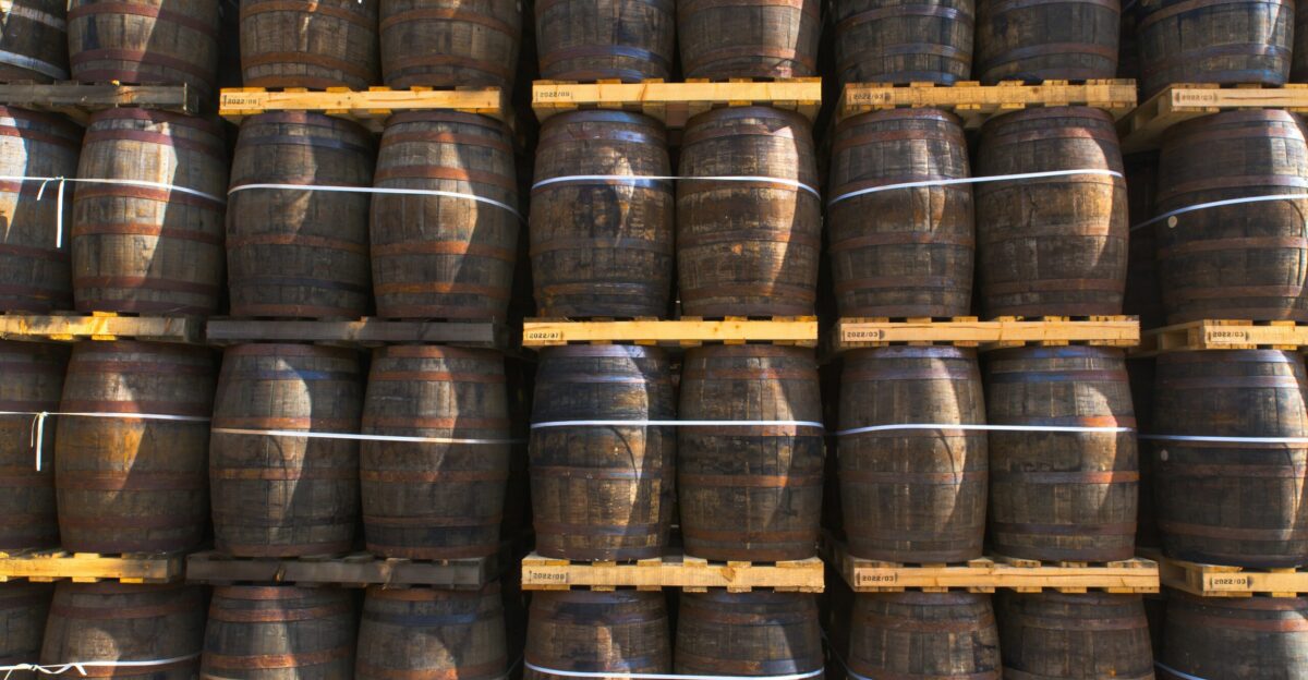 a large stack of wooden barrels in a warehouse