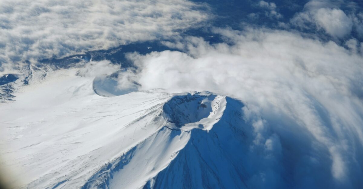 a view of a snow covered mountain from an airplane window