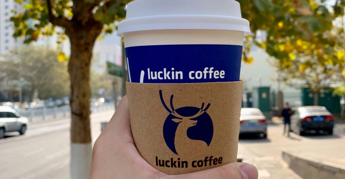 a person holding up a cup of coffee